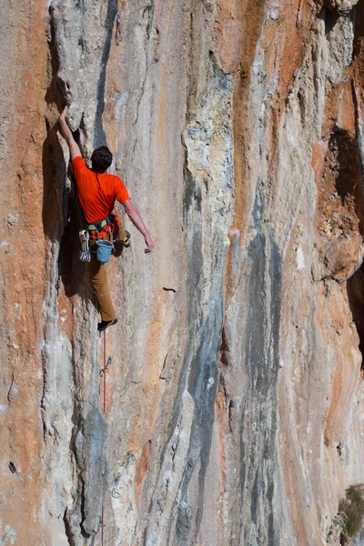 Молодой альпинист висит на скале. — стоковое фото