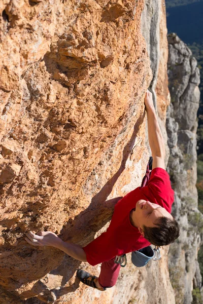 崖にぶら下がっている若い男性登山家. — ストック写真