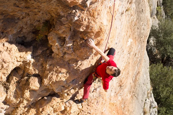 Young male climber hanging by a cliff. — Stock Photo, Image