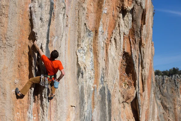 Young male climber hanging by a cliff. — Stock Photo, Image