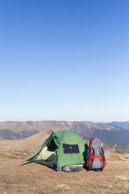 Çadır için bağlı güneş paneli. Güneş'ten cep telefon ücretleri yanında oturan adam.
