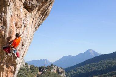 Uçurumun kenarında asılı genç bir tırmanıcı.