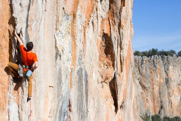 Young male climber hanging by a cliff. — Stock Photo, Image