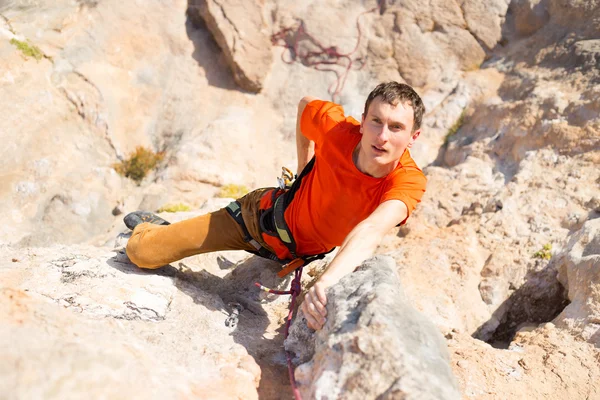 Young male climber hanging by a cliff. — Stock Photo, Image