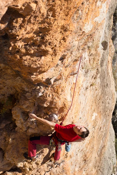 Jovem alpinista pendurado por um penhasco. — Fotografia de Stock