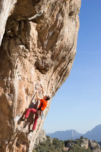 崖にぶら下がっている若い男性登山家. — ストック写真