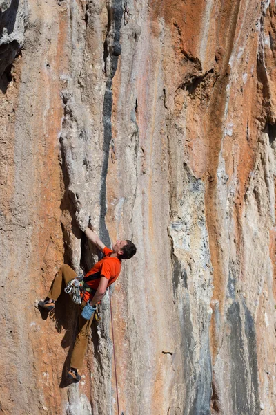 Giovane arrampicatore maschio appeso a una scogliera. — Foto Stock