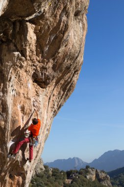 Uçurumun kenarında asılı genç bir tırmanıcı.