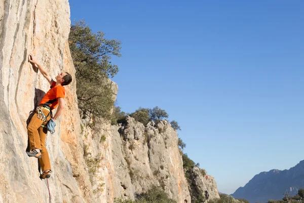 Uçurumun kenarında asılı genç bir tırmanıcı.