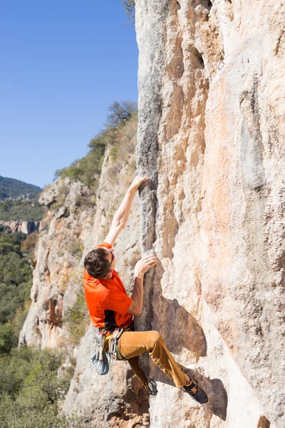 Junger männlicher Kletterer hängt an einer Klippe. — Stockfoto