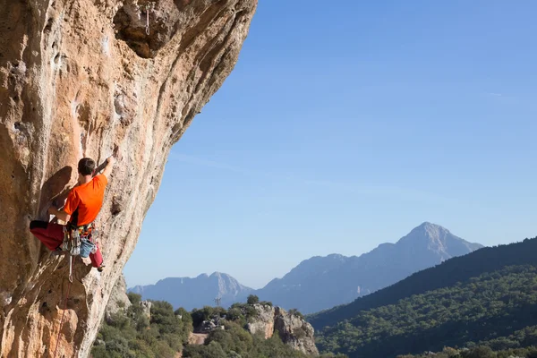 Jovem alpinista pendurado por um penhasco. — Fotografia de Stock