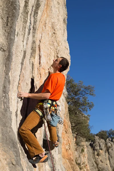 Young male climber hanging by a cliff. — Stock Photo, Image