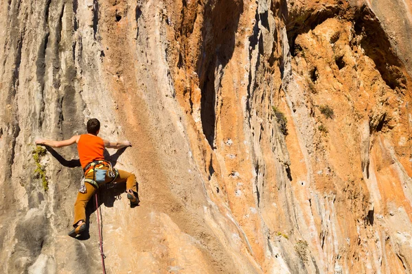 崖にぶら下がっている若い男性登山家. — ストック写真