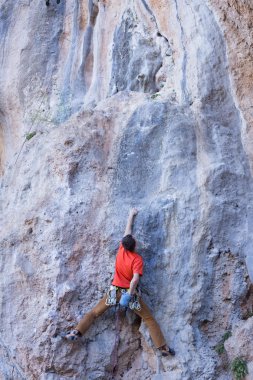 Uçurumun kenarında asılı genç bir tırmanıcı.