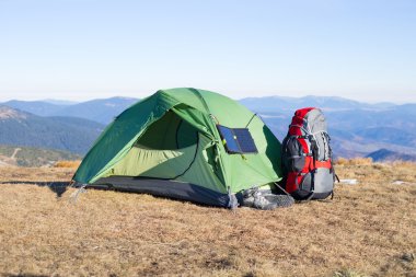 Çadır için bağlı güneş paneli. Güneş'ten cep telefon ücretleri yanında oturan adam.