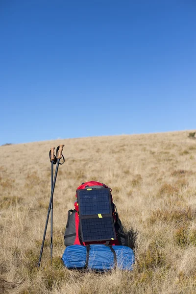 Die Solarzelle, die am Zelt befestigt ist. Der Mann sitzt neben Handyladungen von der Sonne. — Stockfoto