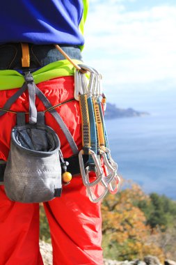 Genç adam gün doğumunda dağları olan bir vadide kayalık bir duvara tırmanır..