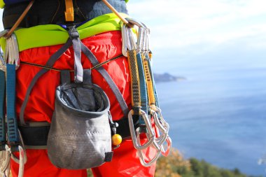 Genç adam gün doğumunda dağları olan bir vadide kayalık bir duvara tırmanır..