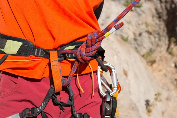 Young man climbing on a limestone wall with wide valley on the background — Stock Photo, Image