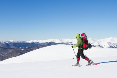 Dağlarda kar ayakkabıları bir sırt çantası ve çadır hiking kış.