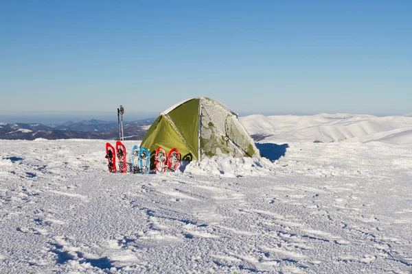 Randonnée hivernale en montagne en raquettes avec sac à dos et tente . — Photo