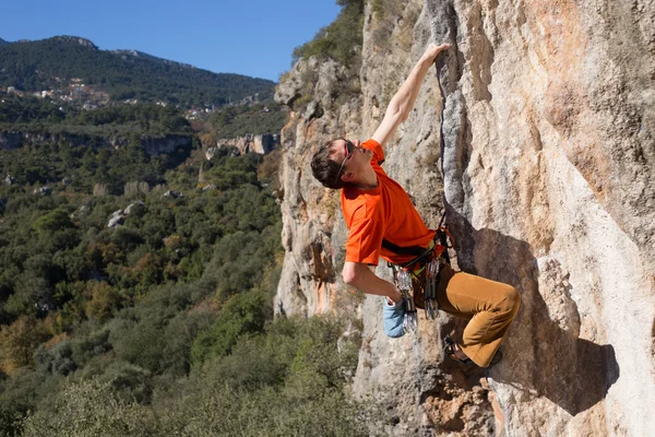 Ung manlig klättrare hängande vid en klippa. — Stockfoto