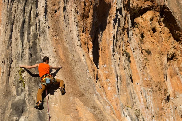 崖にぶら下がっている若い男性登山家. — ストック写真