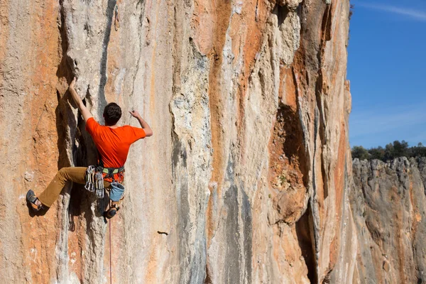 Joven escalador colgado por un acantilado. — Foto de Stock