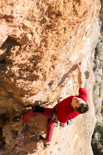 Jeune grimpeur masculin pendu par une falaise. — Photo