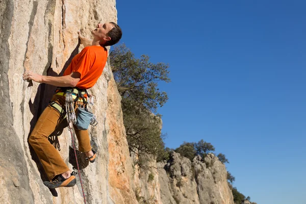 Junger männlicher Kletterer hängt an einer Klippe. — Stockfoto