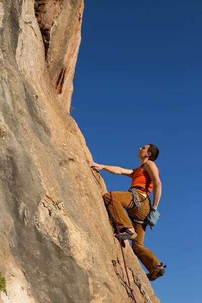 Young male climber hanging by a cliff. Stock Picture