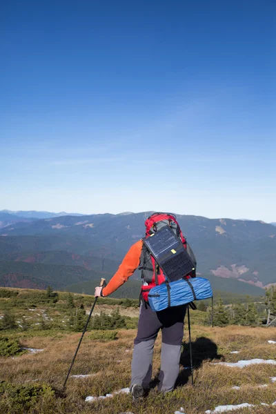 Die Solarzelle, die am Zelt befestigt ist. Der Mann sitzt neben Handyladungen von der Sonne. — Stockfoto