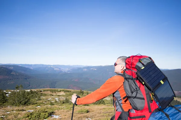 Het zonnepaneel gekoppeld aan de tent. De man zit naast mobiele telefoonkosten van de zon. — Stockfoto