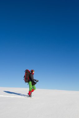 Dağlarda kar ayakkabıları bir sırt çantası ve çadır hiking kış.