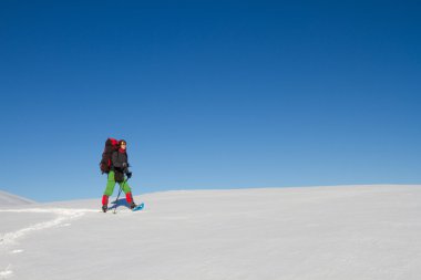 Dağlarda kar ayakkabıları bir sırt çantası ve çadır hiking kış.