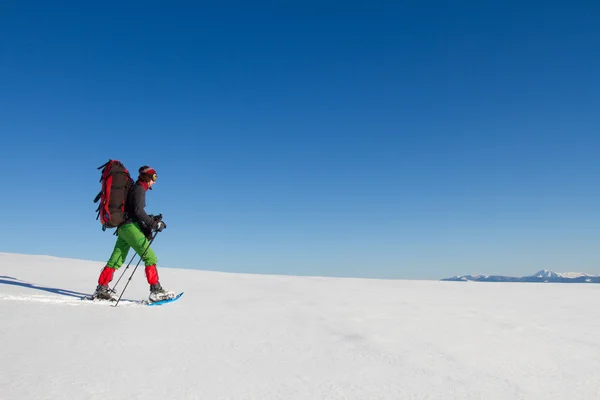 Escursioni invernali in montagna con le ciaspole con zaino e tenda . — Foto Stock