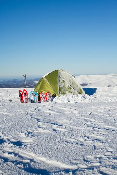 Tent winter mountains.Tent stands in the mountains in the snow. Snowshoes are beside the tent. — Stock Photo, Image