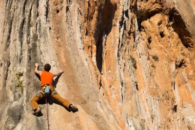 Uçurumun kenarında asılı genç bir tırmanıcı.