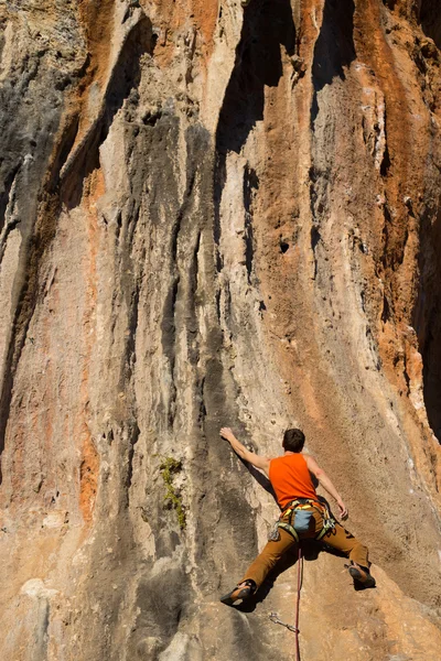 崖にぶら下がっている若い男性登山家. — ストック写真