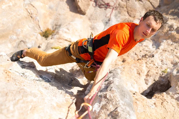 Giovane arrampicatore maschio appeso a una scogliera. — Foto Stock