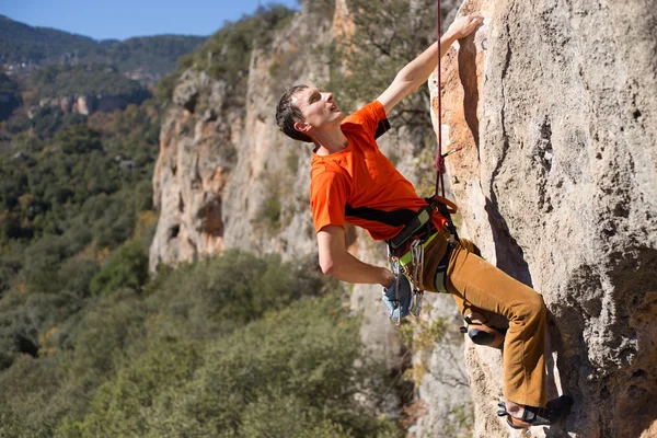 Jeune grimpeur masculin pendu par une falaise. — Photo