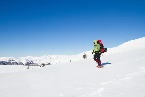 在山里徒步旅行带着背包和帐篷雪的冬天. — 图库照片