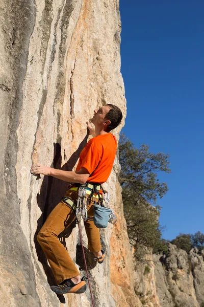 Young male climber hanging by a cliff. — Stock Photo, Image