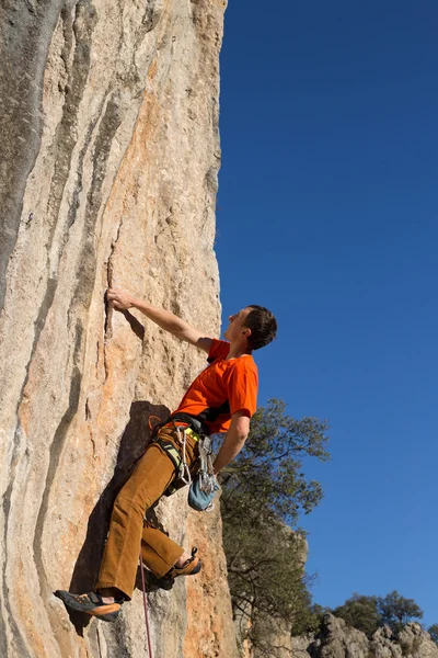 Jovem alpinista pendurado por um penhasco. — Fotografia de Stock