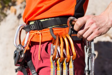 Genç adam arka planında geniş bir vadiyle kireçtaşı bir duvara tırmanıyor.