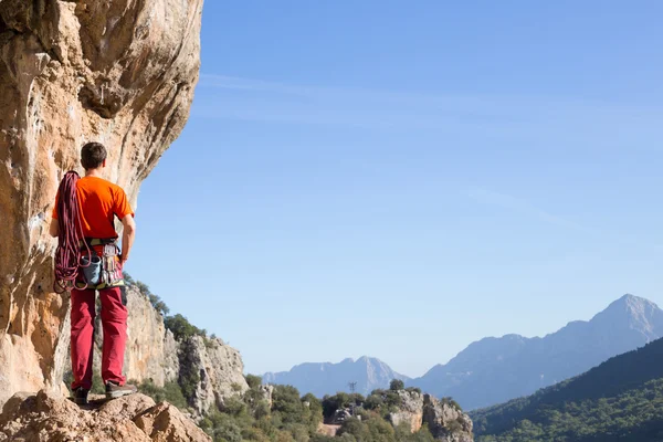 Jovem escalando em uma parede de pedra calcária com amplo vale no fundo — Fotografia de Stock