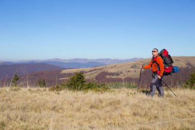 Adam bir sırt çantası ve çadır ile dağlarda hiking.