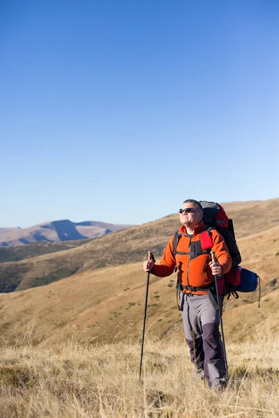 Adam bir sırt çantası ve çadır ile dağlarda hiking. — Stok fotoğraf