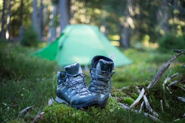 Туристические ботинки возле туристического лагеря — стоковое фото