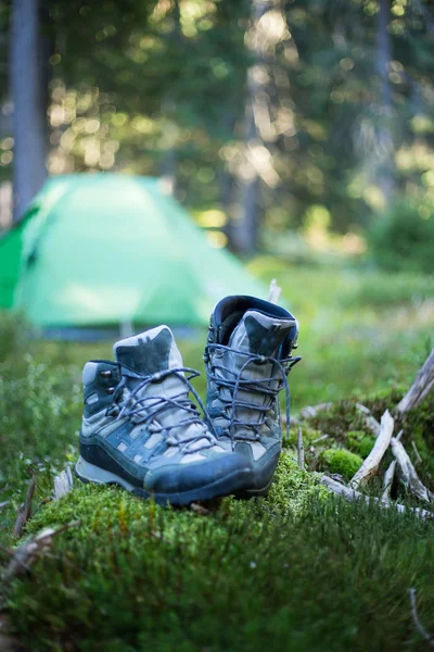 Botas turísticas perto de um acampamento turístico — Fotografia de Stock